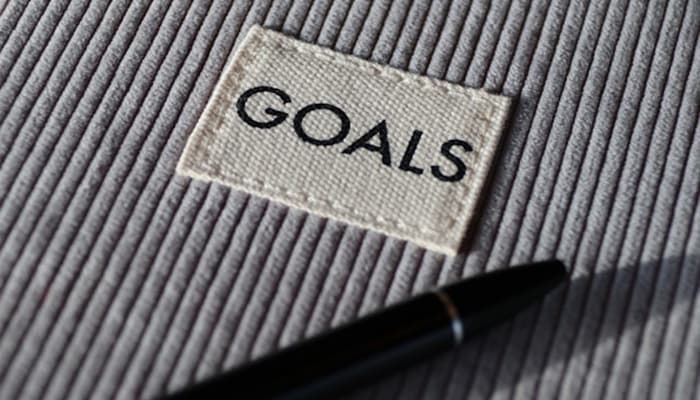 A Patch with the word Goals sewn onto a grey corduroy pattern