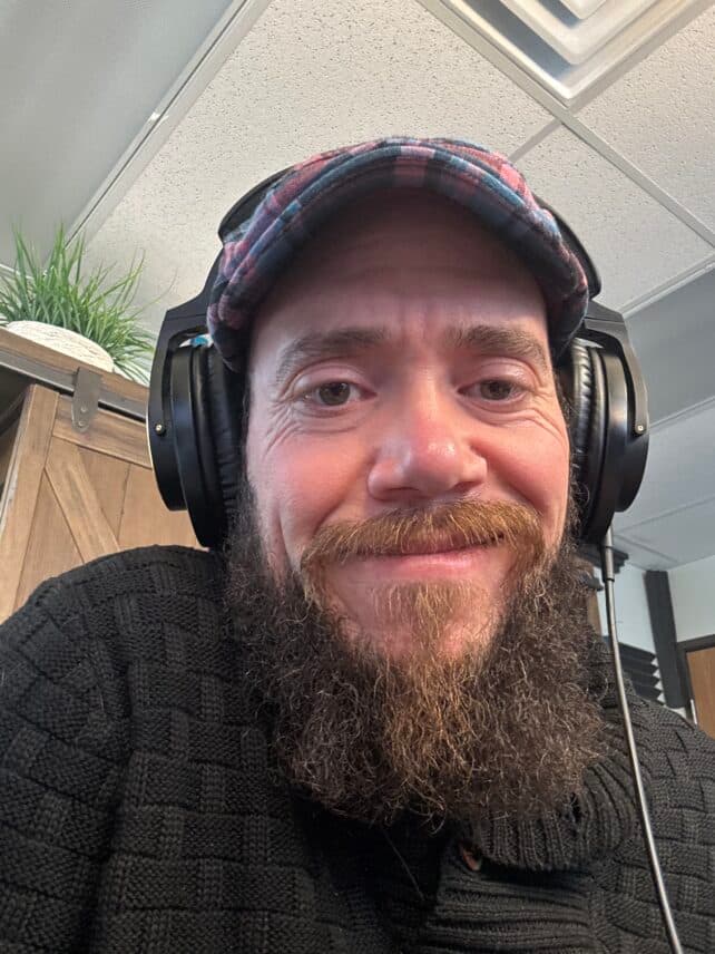 Smiling man with headphones and a hat