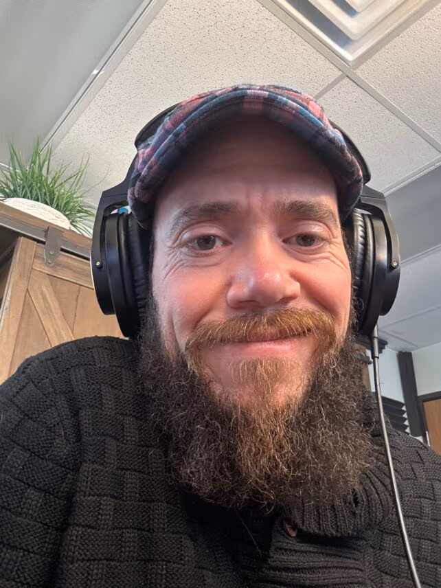 Smiling man with headphones and a hat